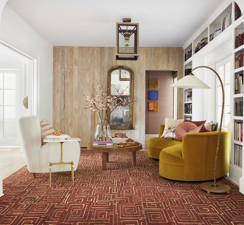 living space with two armchairs, a coffee table, a floor lamp, a mirror, and rust colored carpeting