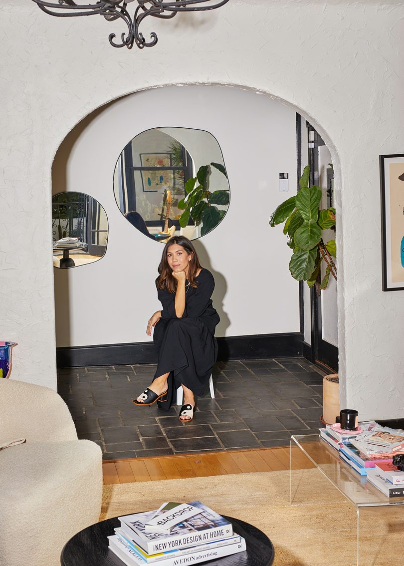 light-skinned woman with dark hair wearing black in indoor living space