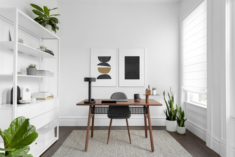 walnut desk and chair in a white light-filled office space