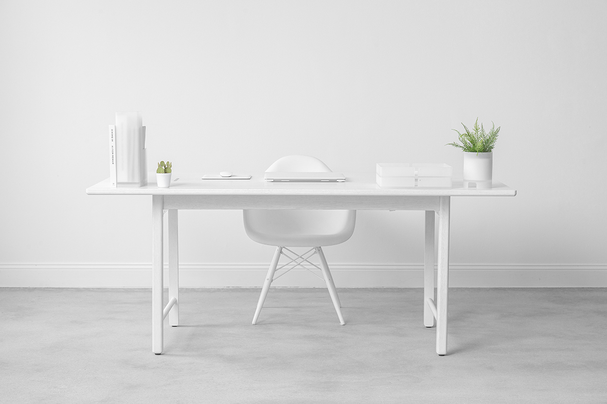 white table with white shell chair behind it