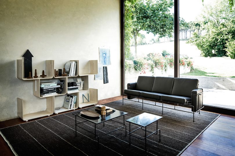 interior living space with cubicle-like shelving, sofa, and coffee table