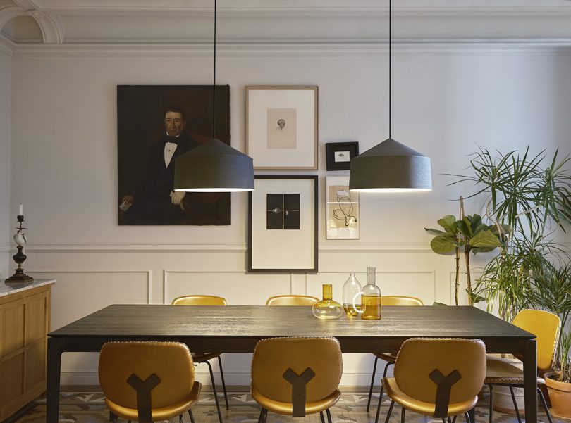 dining space with two grey drum pendant lights and gallery wall