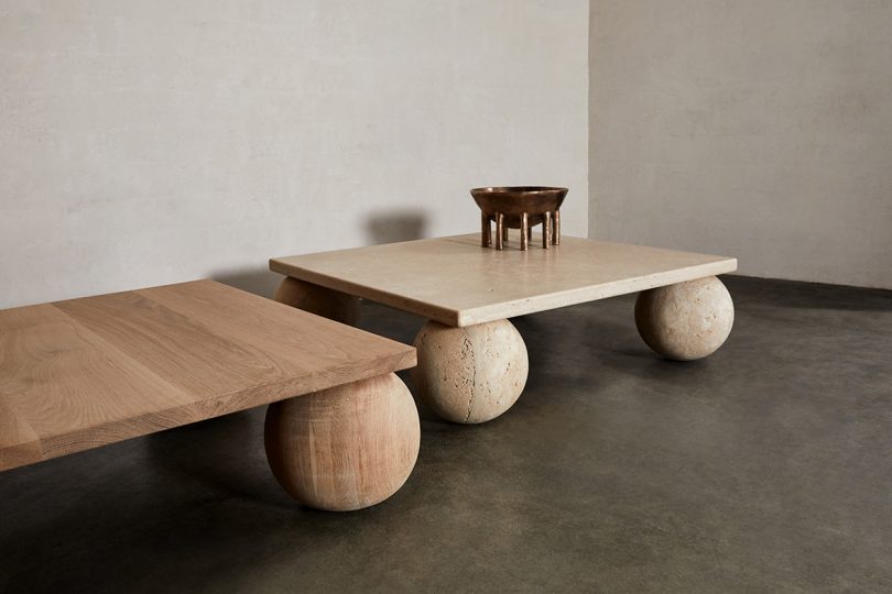 two square coffee tables with orb legs in white space with concrete floor