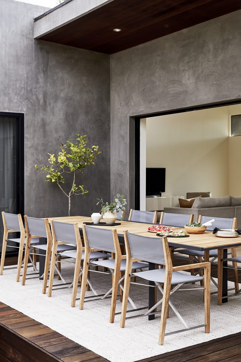 outdoor patio with dining table and ten light grey dining chairs