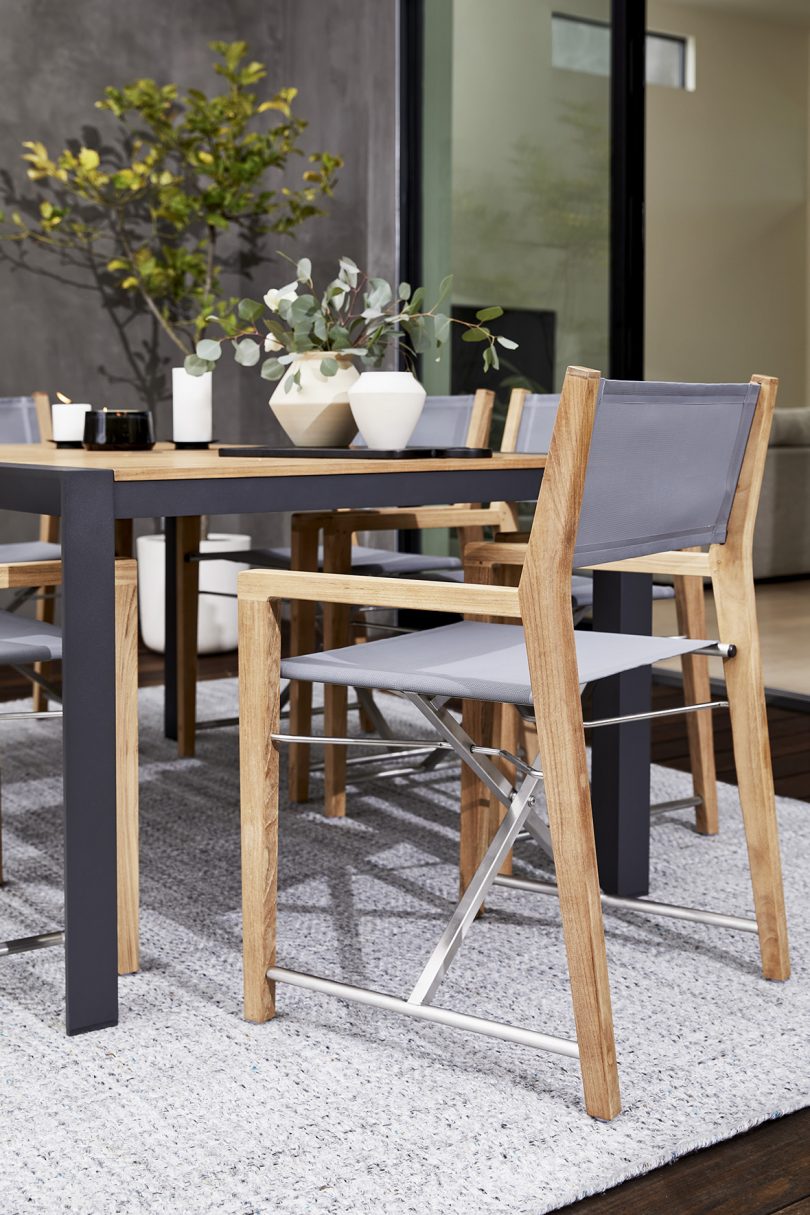 styled outdoor dining table with wood and light grey armchair