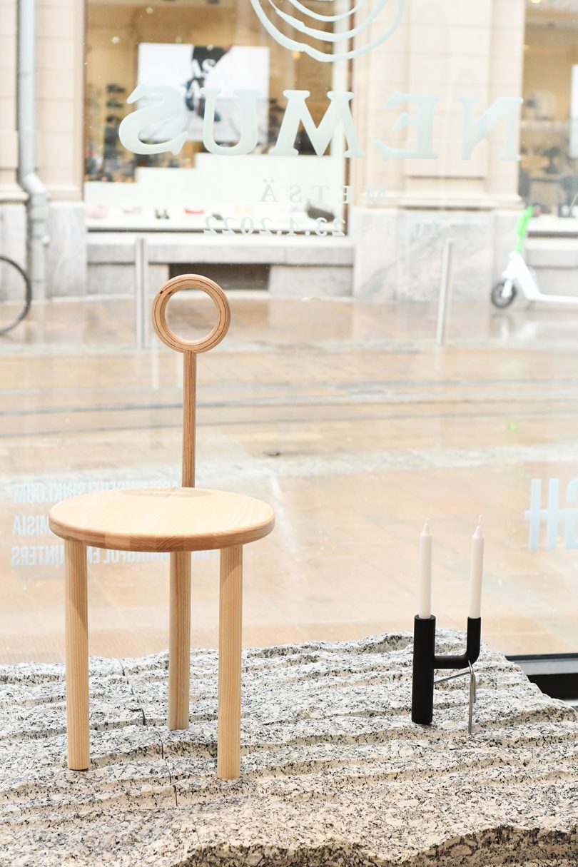 wood chair and candleholder in the window of a gallery space