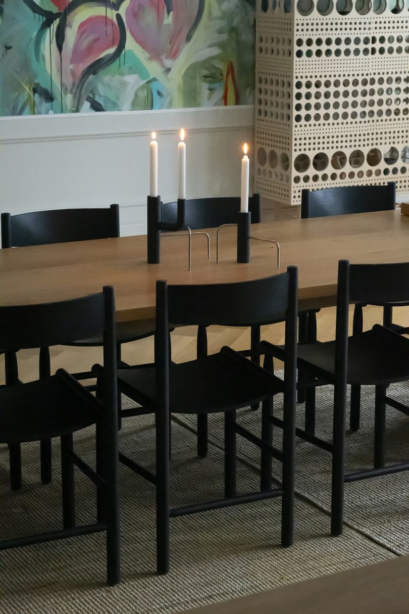 wood dining table surrounded by dark chairs