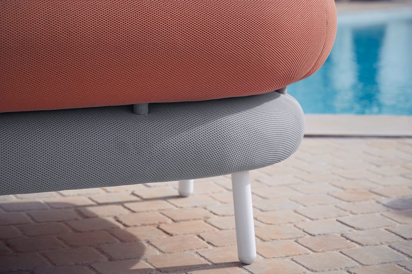 detail of roll back and arm white and coral colored outdoor furniture