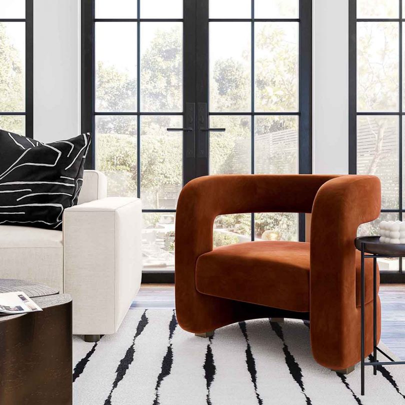 dark orange armchair in living space with white couch and large windows