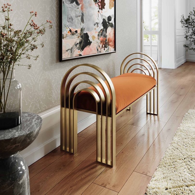 arched brass bench with tan seat in styled interior space