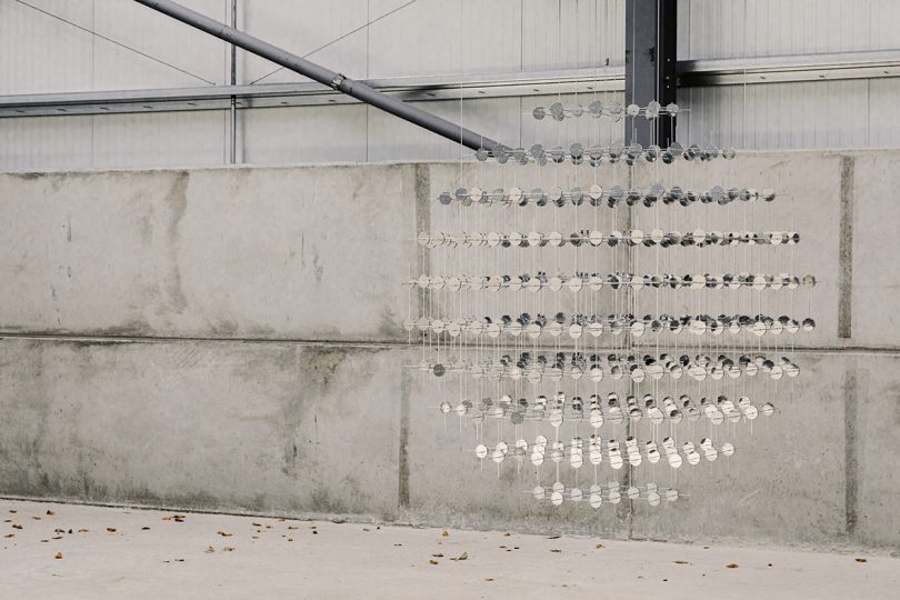 hanging sculpture in cement walled interior space