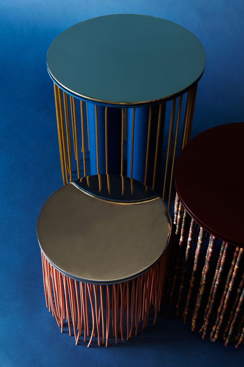 three stacked side tables on dark blue background