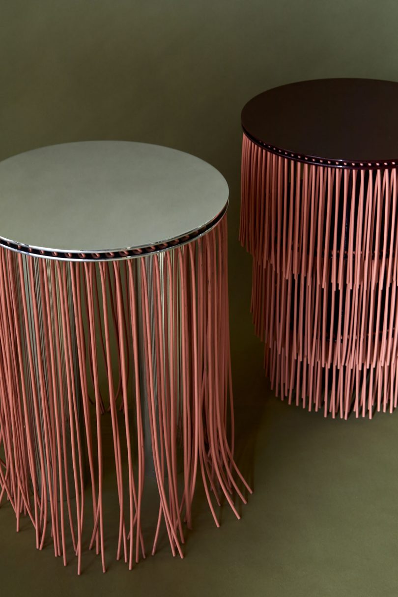 two pink side tables with hanging details