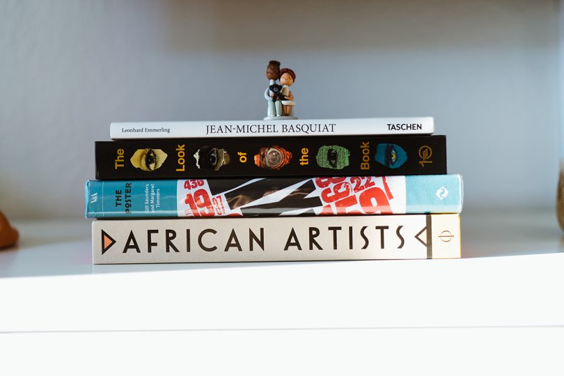 stack of four art books with small figurine on top