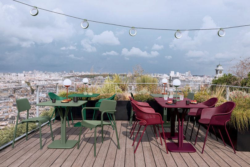 rooftop deck with dining tables and chairs and string lights