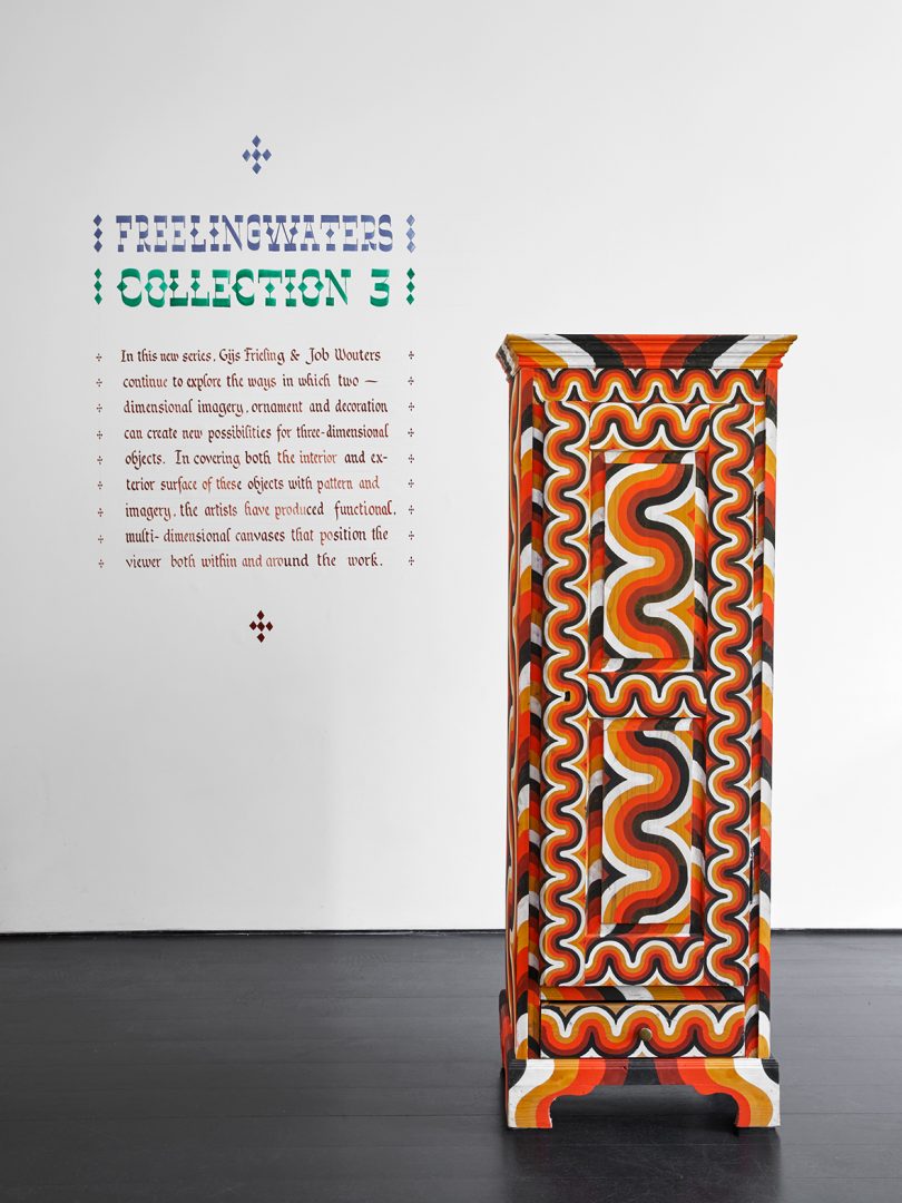 exhibit description next to tall, thin cabinet in a bright pattern