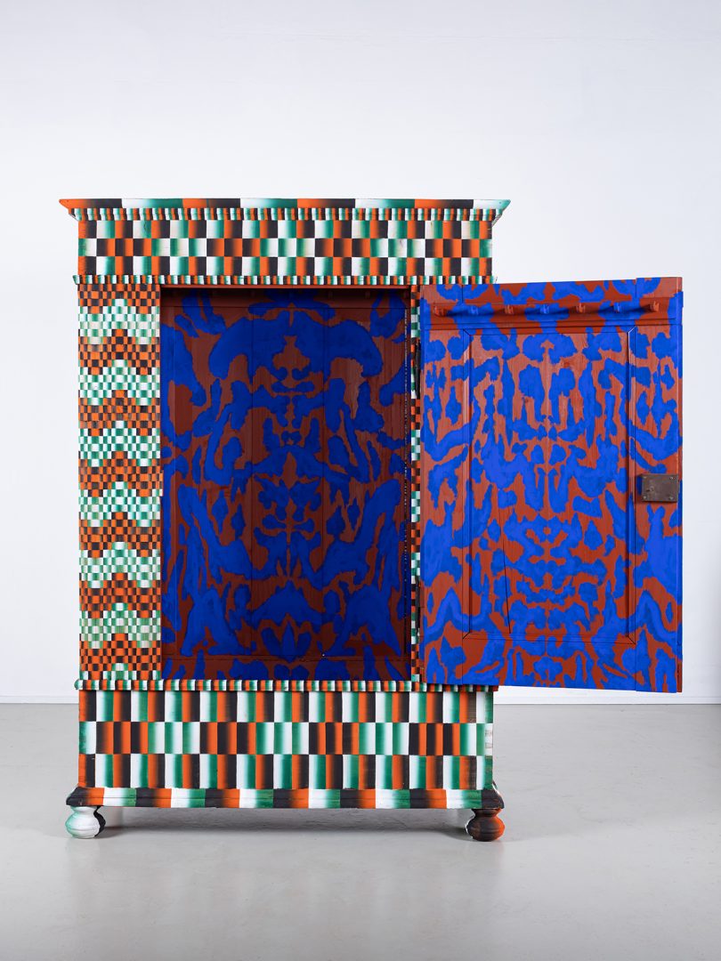 brightly patterned cabinet with door open in exhibit space