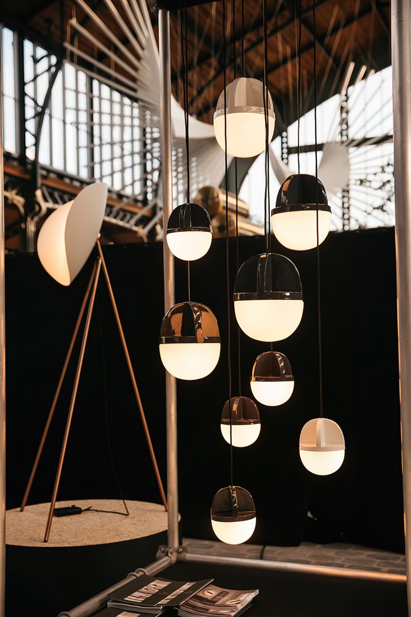 white and black pendant lighting hanging in a warehouse space