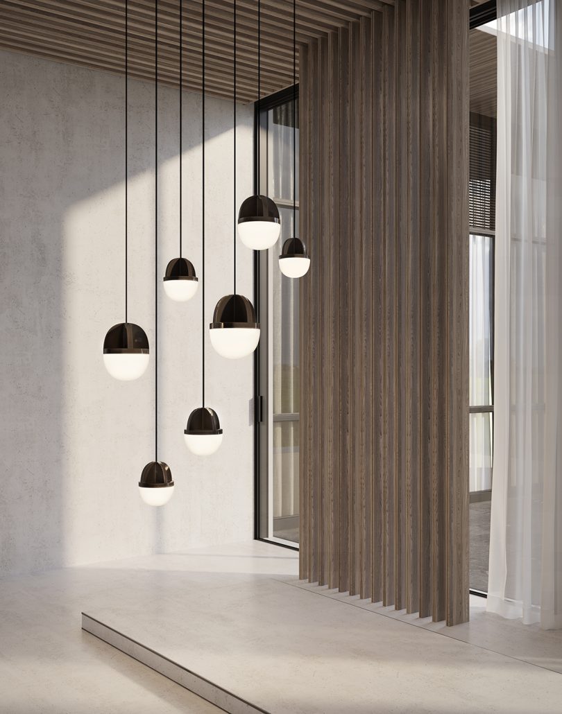 detail of white and rust colored pendant lights hanging from the ceiling in a white space