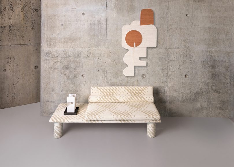 neutral colored patterned sofa with wall sculpture