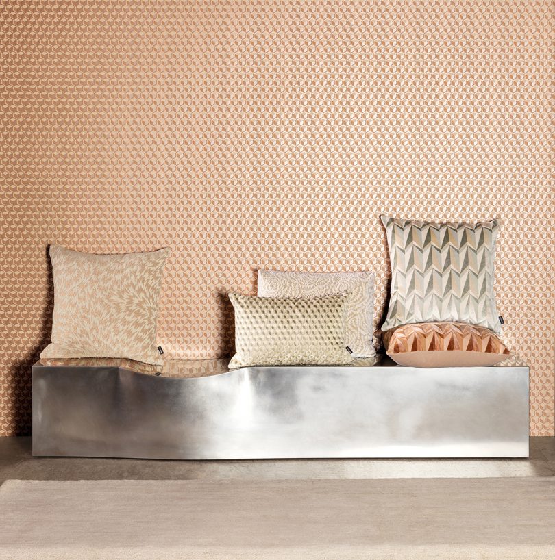 patterned throw pillows atop a piece of silver furniture