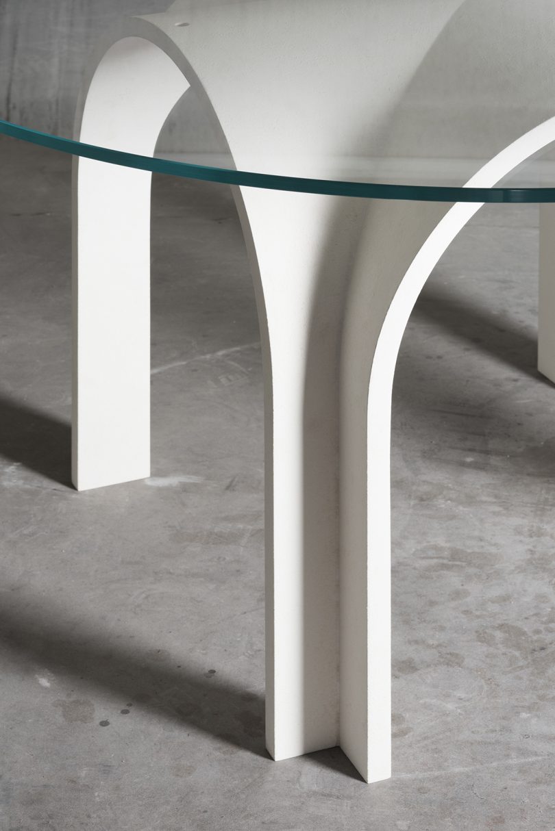 detail of round white four legged dining table in concrete warehouse