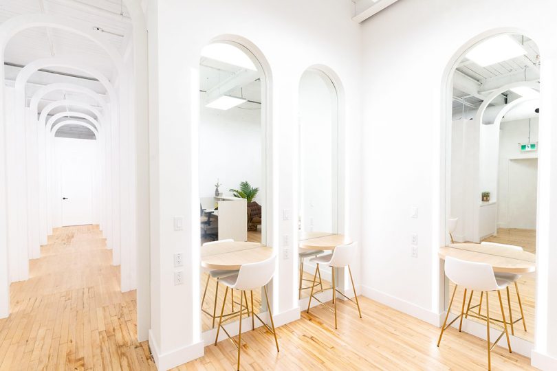 minimal photo studio with two large arched mirrors and stools