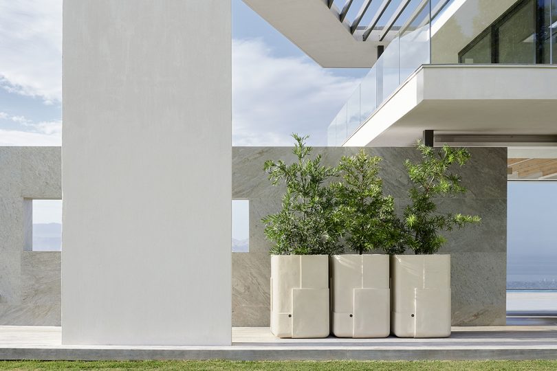 three large white outdoor planters next to white building