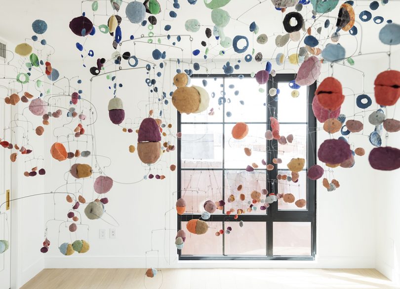 art installation of suspended colored disks in white room