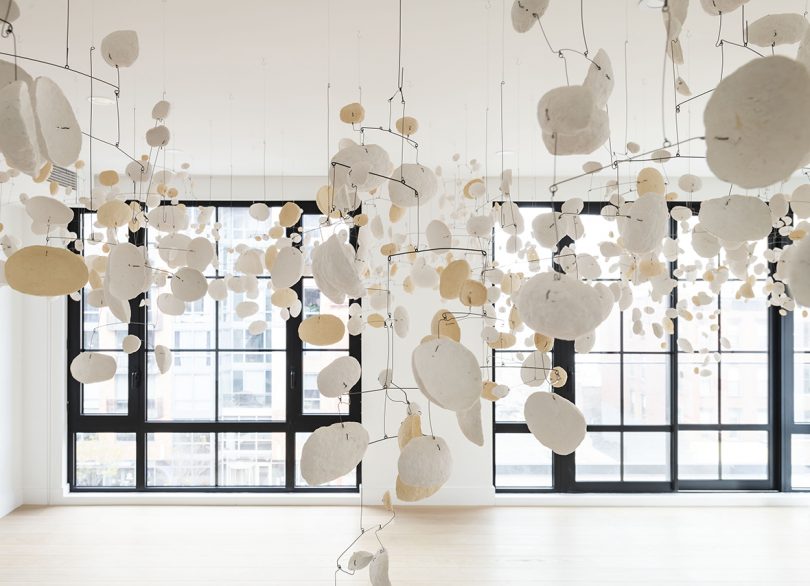 art installation of suspended white disks in white room