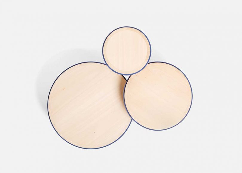 overhead photo of trio of light wood high furniture on white background