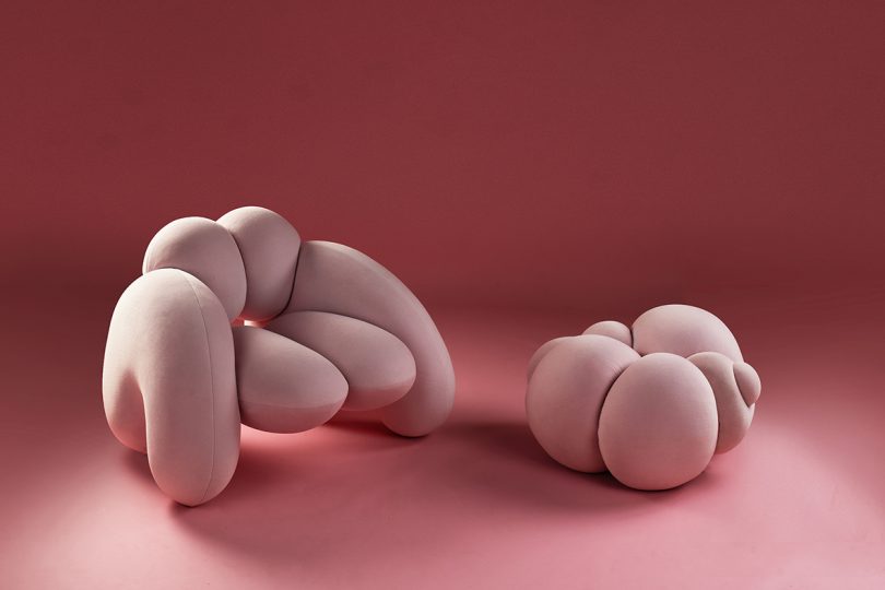 detail of bulbous light pink armchair and pouffe on pink background