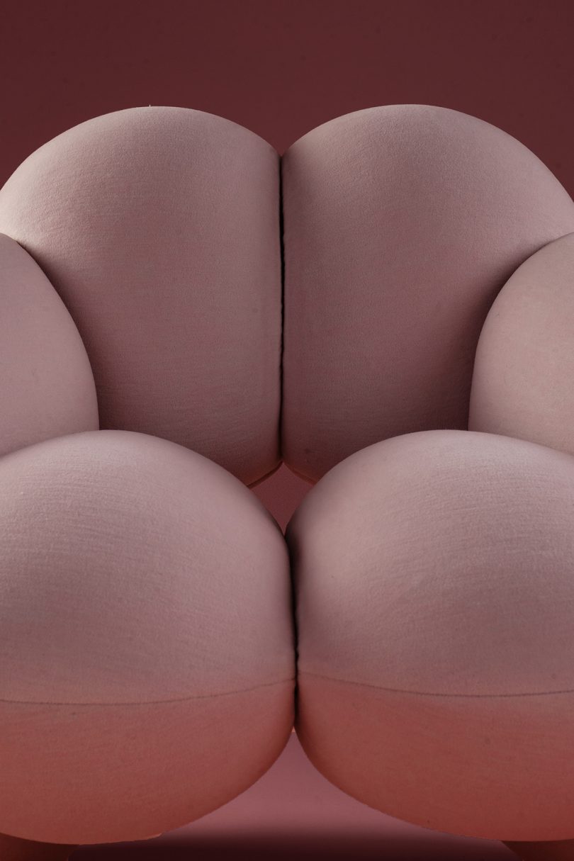 detail of bulbous light pink armchair on pink background