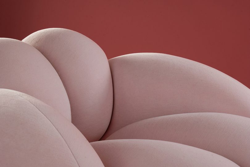 detail of light pink bulbous armchair on pink background