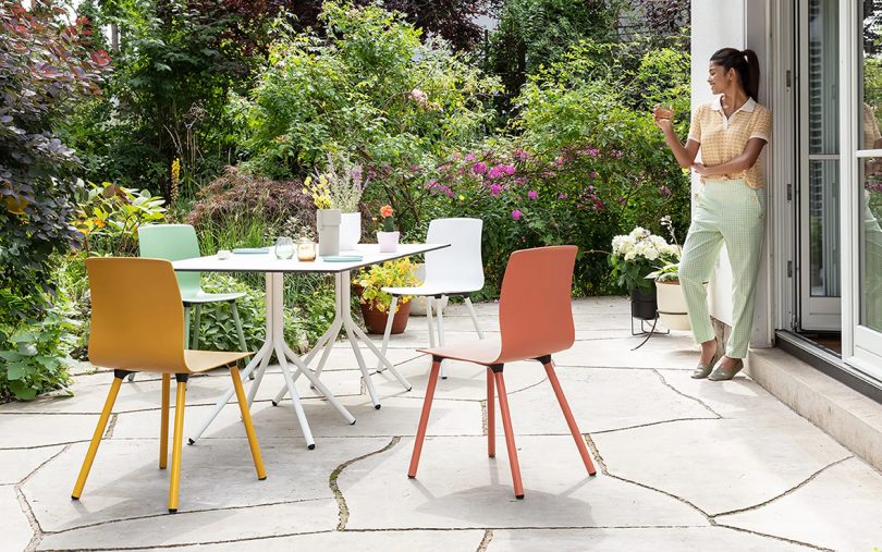 woman standing outdoors near a colorful modern table and chairs set