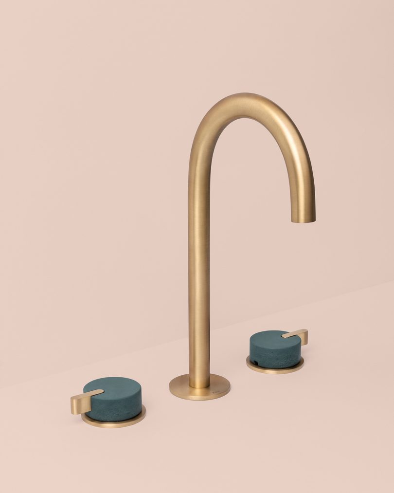 brass and green deck mounted tap on light pink background