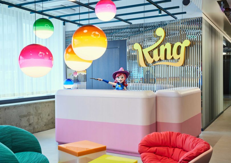 colorful office interior with pink welcome desk with cartoon character behind desk