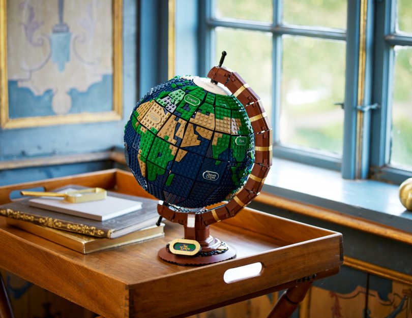 LEGO spinning globe on a tray table in front of a blue window