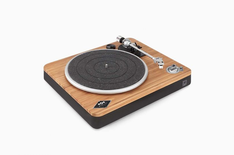 Three-quarter view of Stir It Up Wireless turntable, with bamboo top and black base against light gray background.