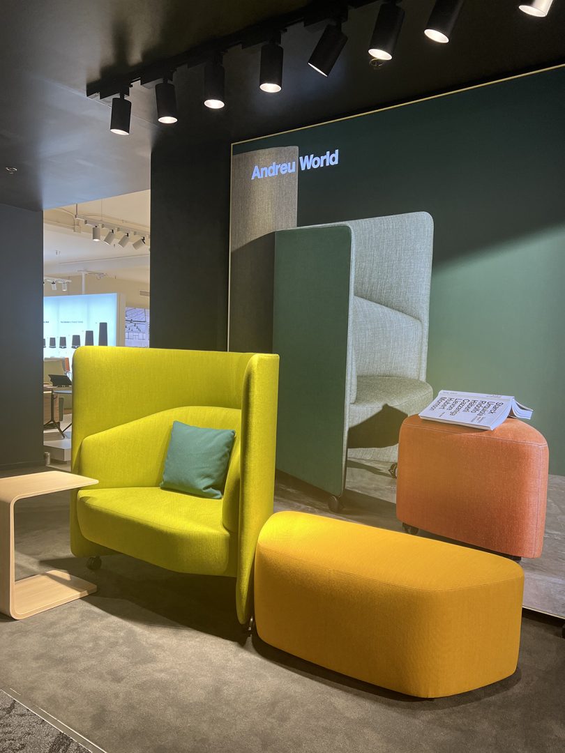 two colorful chairs sit in the hallway in front of a furniture showroom