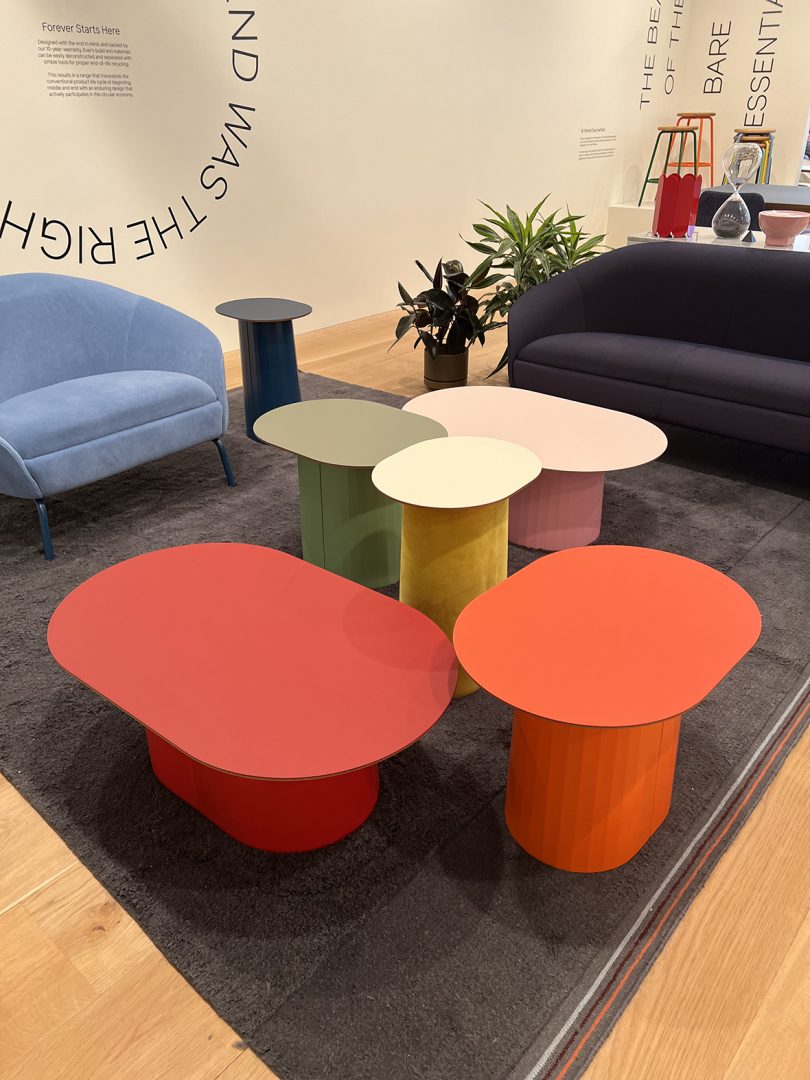 five colorful curvaceous occasional tables in showroom space
