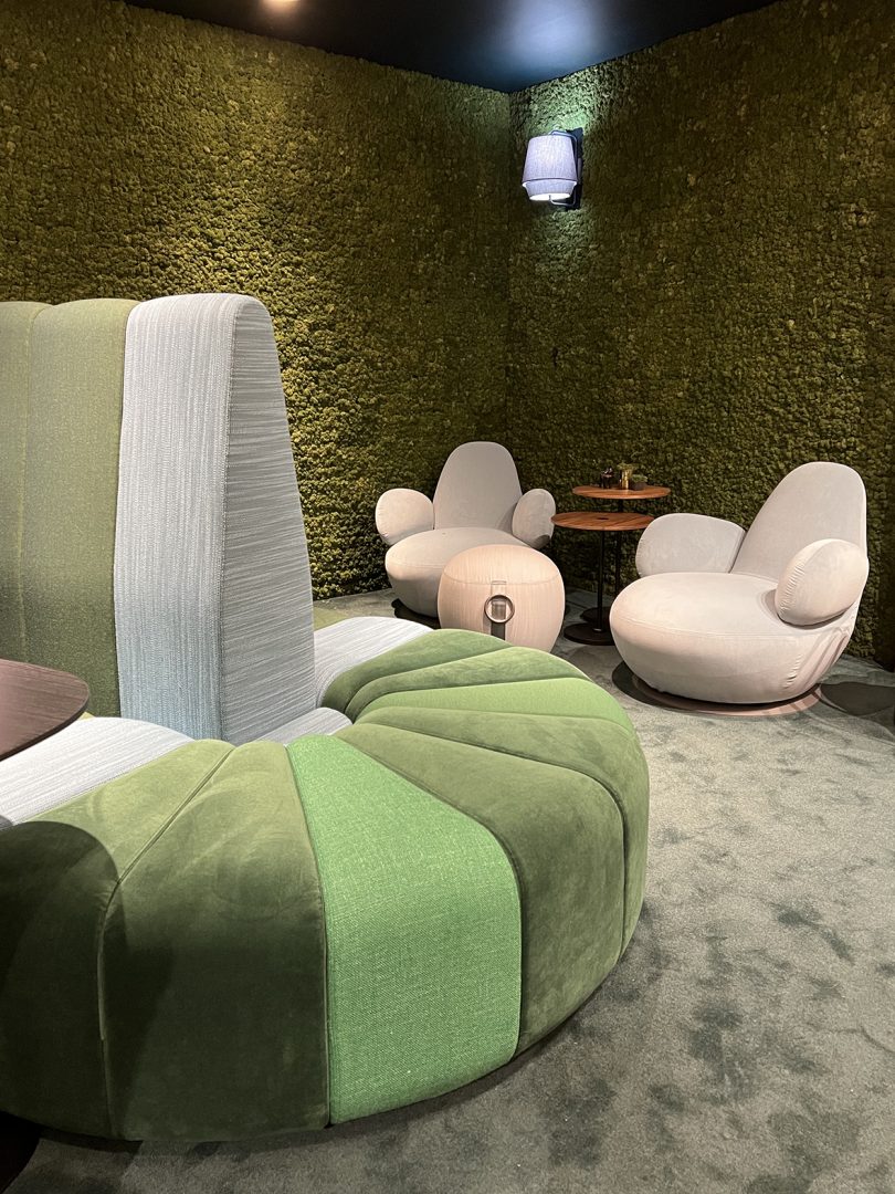 green curvy tufted sofa and two playful white armchairs