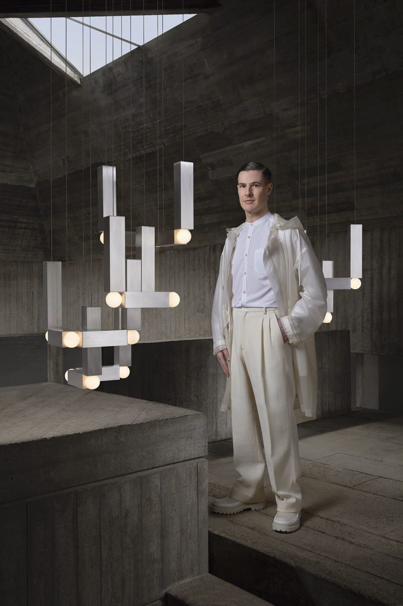 styled abstract silver hanging pendant lights with light-skinned man wearing light colored clothing