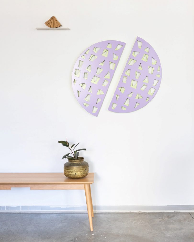 two lilac half circles with intricate woodwork pattern hanging on a wall