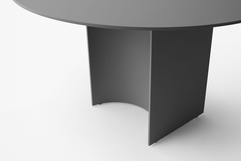 detail of round black dining table on white background