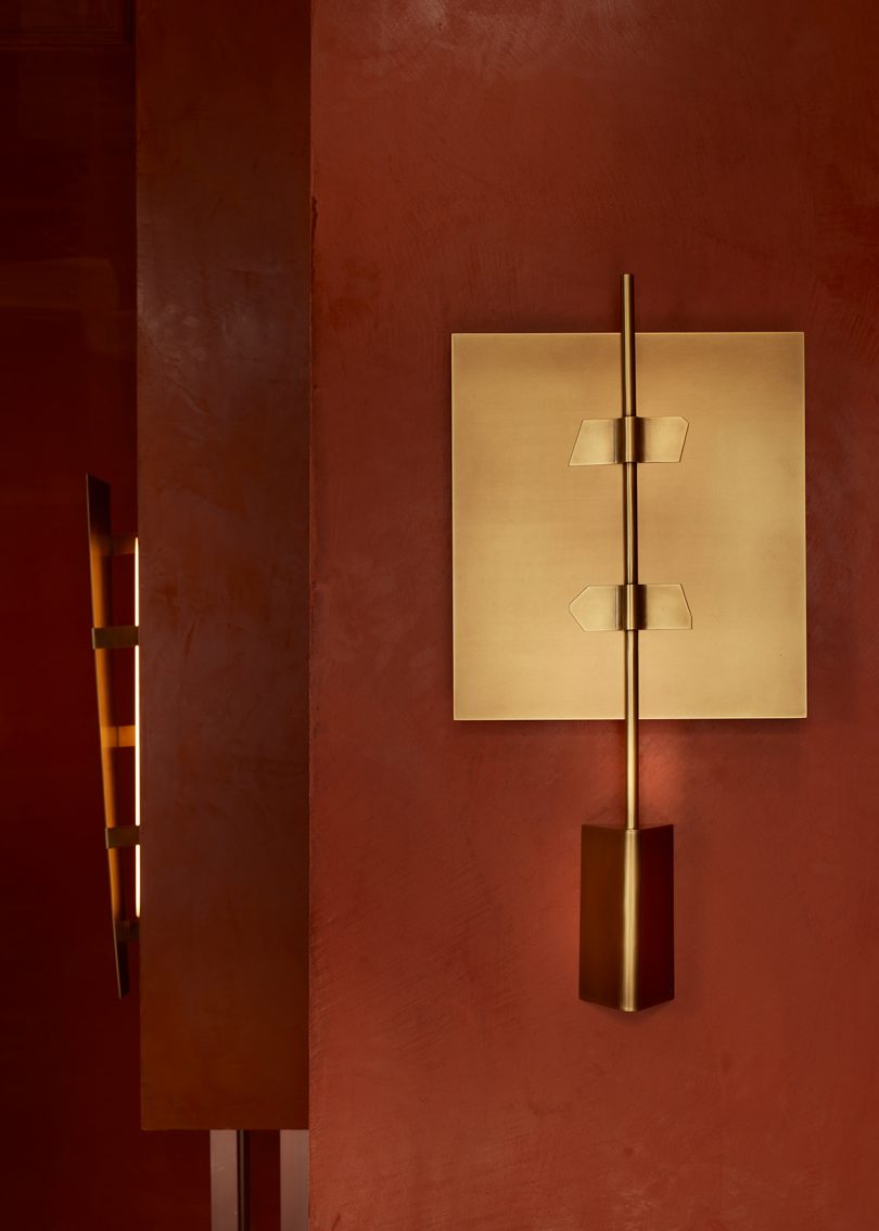 wall sconces in styled room with dark rust walls