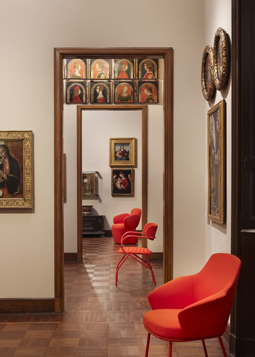 three modern vermillion chairs in a traditional gallery space