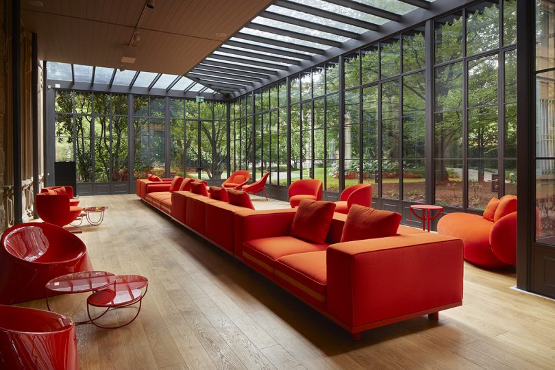 modern vermillion sofas, tables, and chairs in a glass covered sunroom