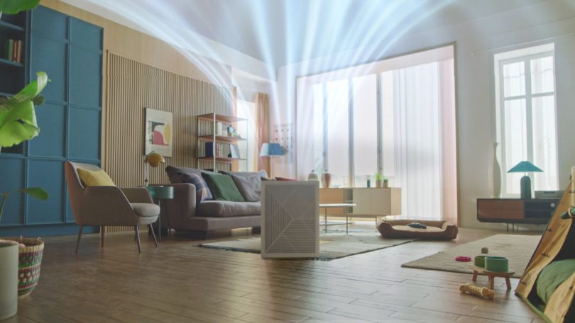 3D animation screen shot illustrating air purifier circulating filtered air flow directed up toward ceiling in living room setting.