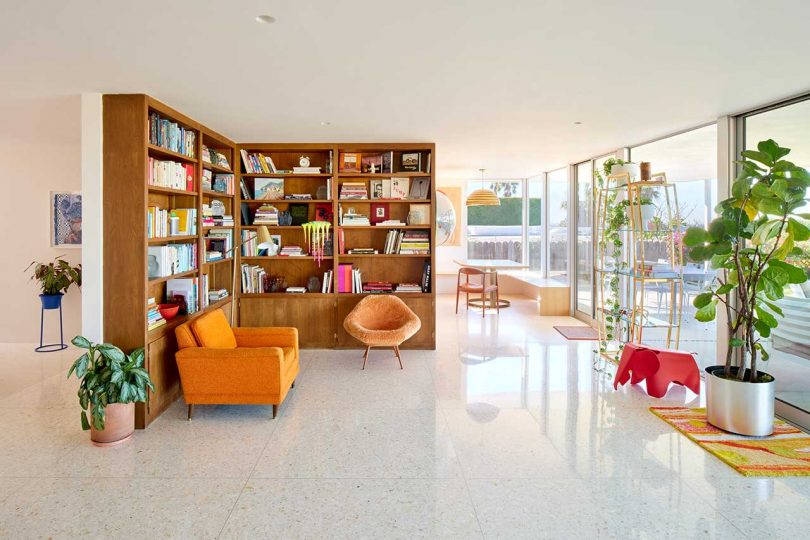 interior of mid-century modern home with bookshelf corner and orange accents